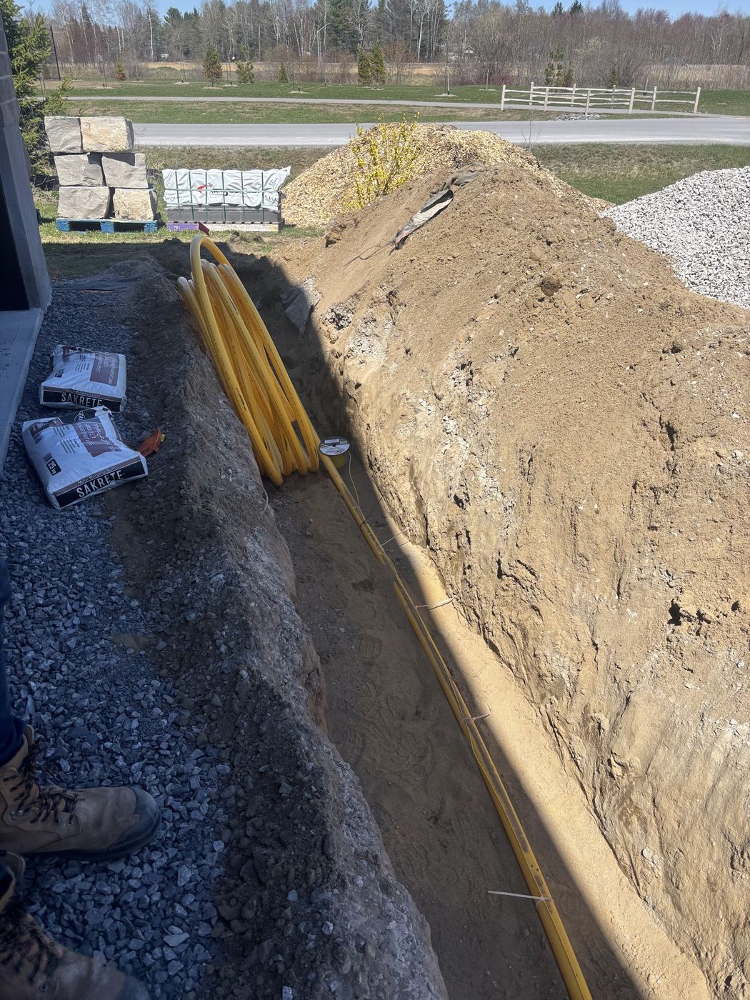 A yellow gas line laid in a dug trench